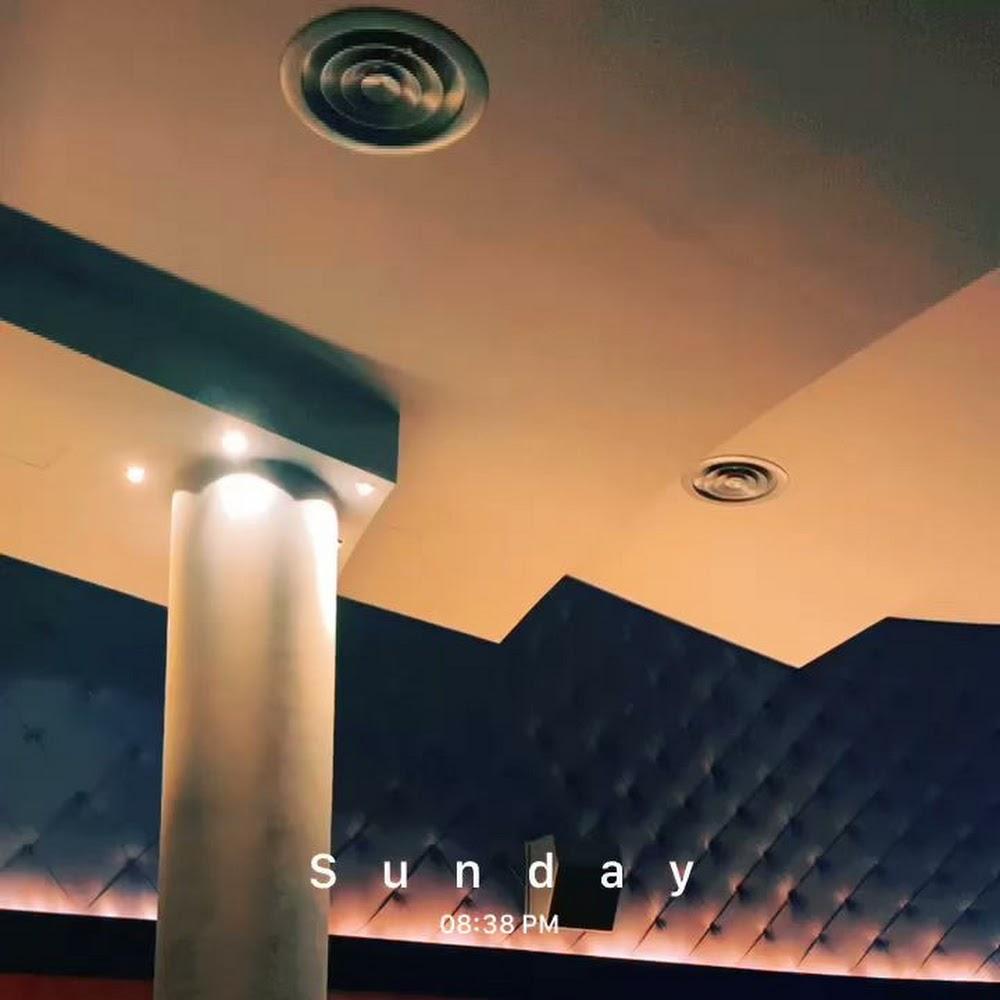 A white pillar, ceiling with lights, and wall with a tufted pattern.